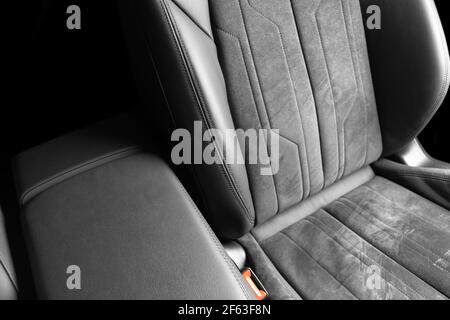 Modern luxury car black leather with alcantara interior. Part of black leather car seat details with white stitching. Interior of prestige car. Perfor Stock Photo