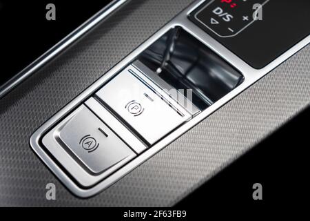Detail of a parking brake in a nodern car. Electronic parking brake button in a modern car. Button closeup. Stock Photo