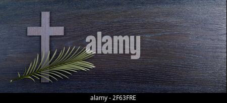 Palm sunday background. Cross and palm on wooden background. Stock Photo