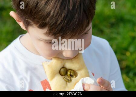 Young Boy Eating Bread whit Olive Stock Photo