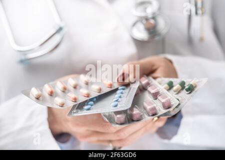 Various colorful blister packagings in hands of a doctor. Stock Photo