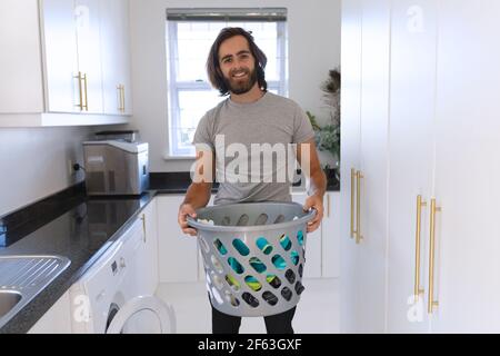 Portrait of caucasian man wearing gray tshirt and doing laundry Stock Photo