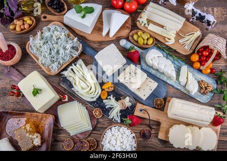 Various types of cheese,wooden old table. Great morning breakfast from Turkish cuisine. types of cheese in vegetables. Stock Photo