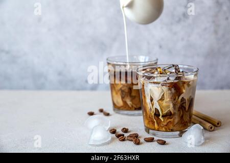 Premium Photo  Iced coffee with milk or cream in a glass jar with a straw  on gray background cold refreshment summer drink