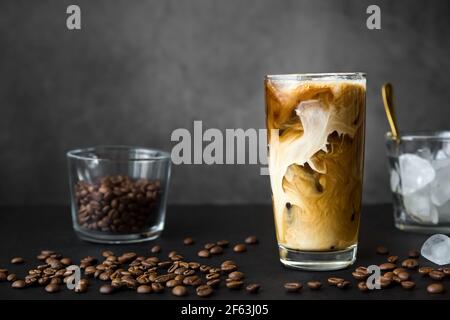 Premium Photo  Iced coffee with milk or cream in a glass jar with a straw  on gray background cold refreshment summer drink