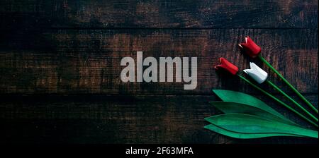 Spring concept, White and Red   woodenTulip or rose decorations on dark wooden Table. Stock Photo