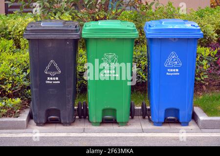 3 Coloured bins for rubbish and recycling in China. Different than the rest of the world they use blue as recycle not green. Stock Photo