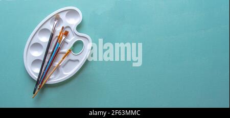 Palette Paints Colors painting color board on blue or turquoises wood color Stock Photo