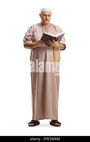 Full length portrait of a muslim man in traditional clothes reading a book isolated on white background Stock Photo
