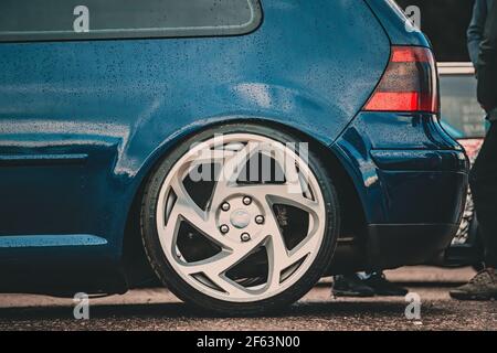 The back of a blue low car. On it polished alloy wheels. Stock Photo