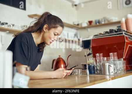 Barista taking order from customer online on smartphone. Concept of cafe and coffee shop small business Stock Photo