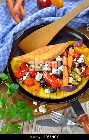 Omelette Greek style with grilled vegetables and  feta cheese served in a frying pan Stock Photo