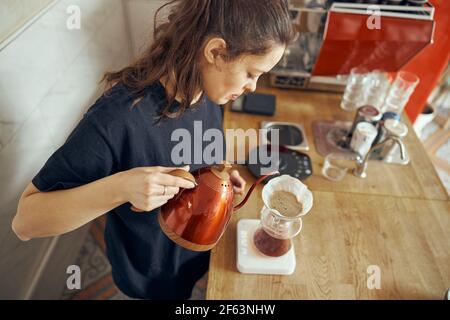 Barista female is making delicious, freshly ground morning coffee powder in the coffee filter Stock Photo