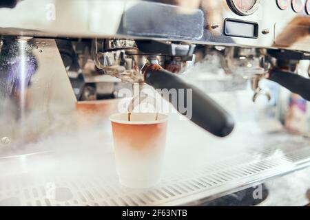 Close-up of espresso pouring from coffee machine. Professional coffee brewing Stock Photo