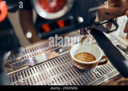 Close-up of espresso pouring from coffee machine. Professional coffee brewing Stock Photo