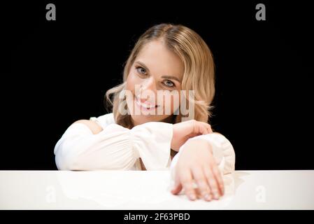 Pianist posing near white piano on the stage Stock Photo