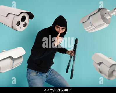 Thief with balaclava was spotted trying to steal in a apartment from the video surveillance system. Stock Photo
