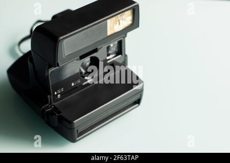 Retro old fashioned instant camera on a white glass background Stock Photo