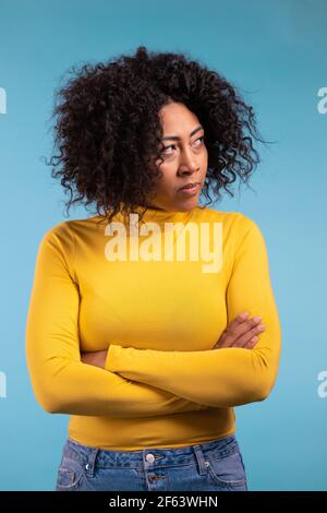 Offended african woman keeping arms crossed, feeling mad at someone. Human facial expressions, emotions and feelings. Body language Stock Photo