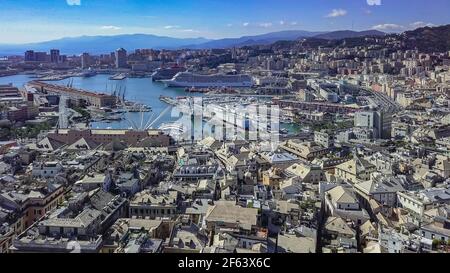 Aerial panoramic drone view of buildings and streets surrounding Port of Genoa.Cruise ships and ferries in port.Old famous city of Italy, with beautif Stock Photo