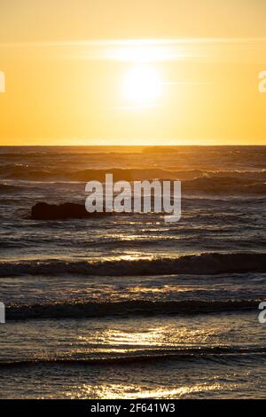 The sun setting over the rough seas of the Pacific Ocean off the coast of Washington State. Stock Photo
