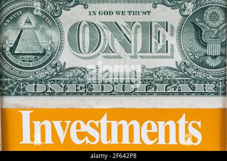 US one dollar paper currency banknote above the word Investments in bold white letters on orange background Stock Photo