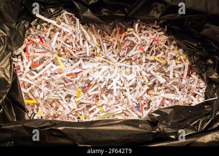 Close-up of shredded paper in black plastic garbage bag Stock Photo