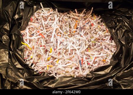 Close-up of shredded paper in black plastic garbage bag Stock Photo