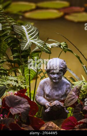Sculpture of a boy holding a turtle at the Botanic Gardens, in Singapore. Stock Photo