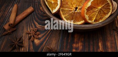 dried orange slices in a plate on a dark wooden table Stock Photo