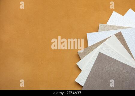 Background of genuine light brown leather and leather samples of different colors Stock Photo