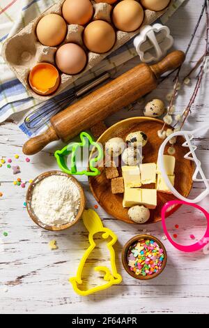 Baking or cooking background frame. Ingredients, kitchen items for Easter festive baking. Kitchen utensils, flour, brown sugar, eggs, butter, confetti Stock Photo