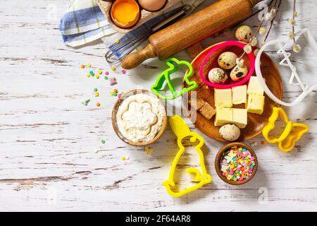 Baking or cooking background frame. Ingredients, kitchen items for Easter festive baking. Kitchen utensils, flour, brown sugar, eggs, butter, confetti Stock Photo