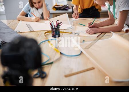 Adorable female kids drafting sewing patterns in workshop Stock Photo