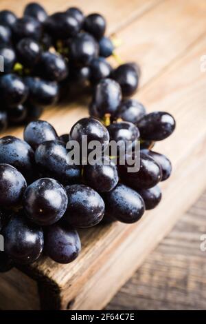 Ripe black grape on the rustic background. Selective focus. Shallow depth of field. Stock Photo