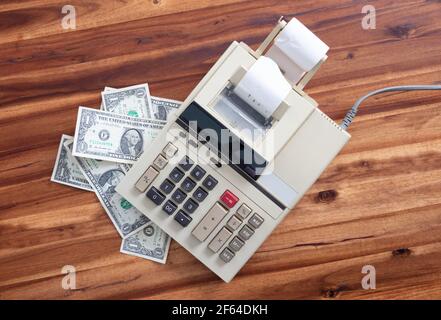 Old fashioned calculator and dollars on a desk Stock Photo