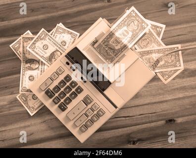Old fashioned calculator and dollars on a desk Stock Photo