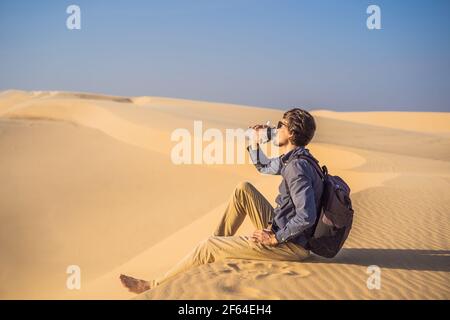 Man feels thirst and drinks water in the desert Stock Photo
