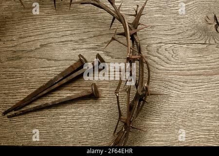 Crown of thorns with three nails on wooden background. Easter concept. Stock Photo