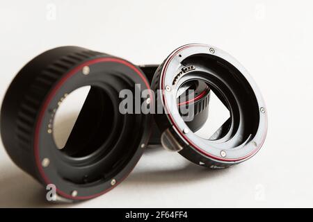 Macro rings for camera lens close-up on a gray background. Professional macro photography, additional features, plastic rings with a chip. Three rings Stock Photo