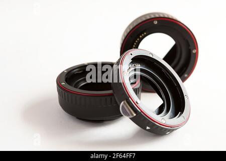 Macro rings for camera lens close-up on a gray background. Professional macro photography, additional features, plastic rings with a chip. Three rings Stock Photo