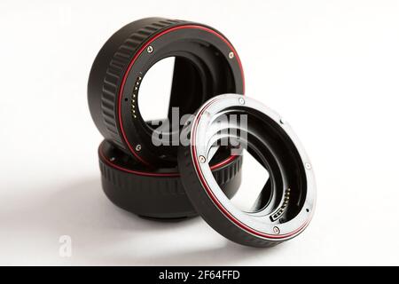 Macro rings for camera lens close-up on a gray background. Professional macro photography, additional features, plastic rings with a chip. Three rings Stock Photo