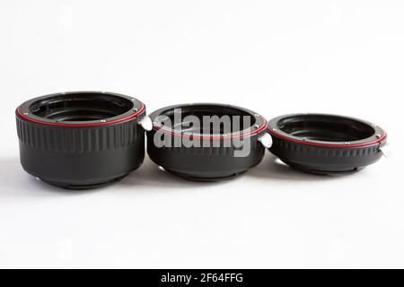 Macro rings for camera lens close-up on a gray background. Professional macro photography, additional features, plastic rings with a chip. Three rings Stock Photo