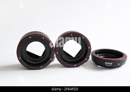 Macro rings for camera lens close-up on a gray background. Professional macro photography, additional features, plastic rings with a chip. Three rings Stock Photo