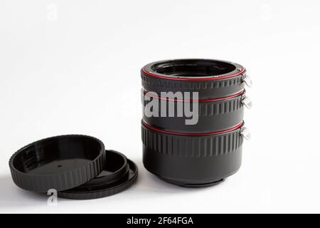 Macro rings for camera lens close-up on a gray background. Professional macro photography, additional features, plastic rings with a chip. Three rings Stock Photo