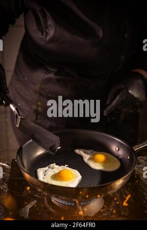 Sunny side up eggs in frying pan in restaurant kitchen Stock Photo