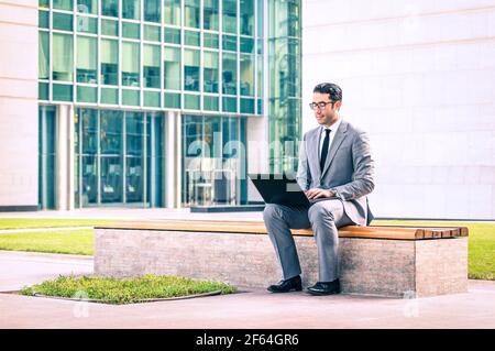 Young hipster business man sitting with laptop at business center - Modern concept of technology wifi connection Stock Photo