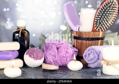 Spa resort therapy composition. Bath bomb, burning candles, towel, massage oil, soap, washcloths, combs Top view Soft focus Stock Photo