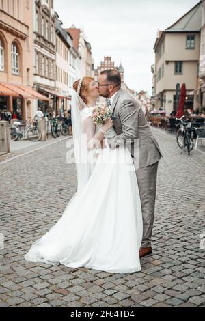 Bridal couple kissing in the middle of the street Stock Photo