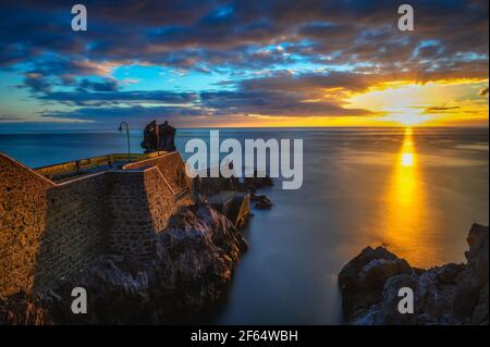 Sunset at the pier of Ponta do Sol in Madeira Island, Portugal Stock Photo